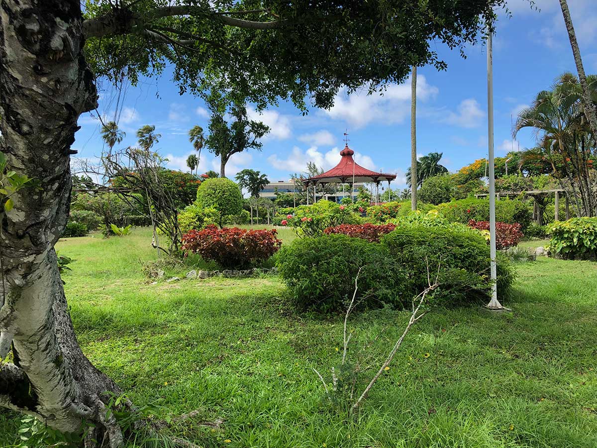 A gazebo in the distance surrounded by more green trees