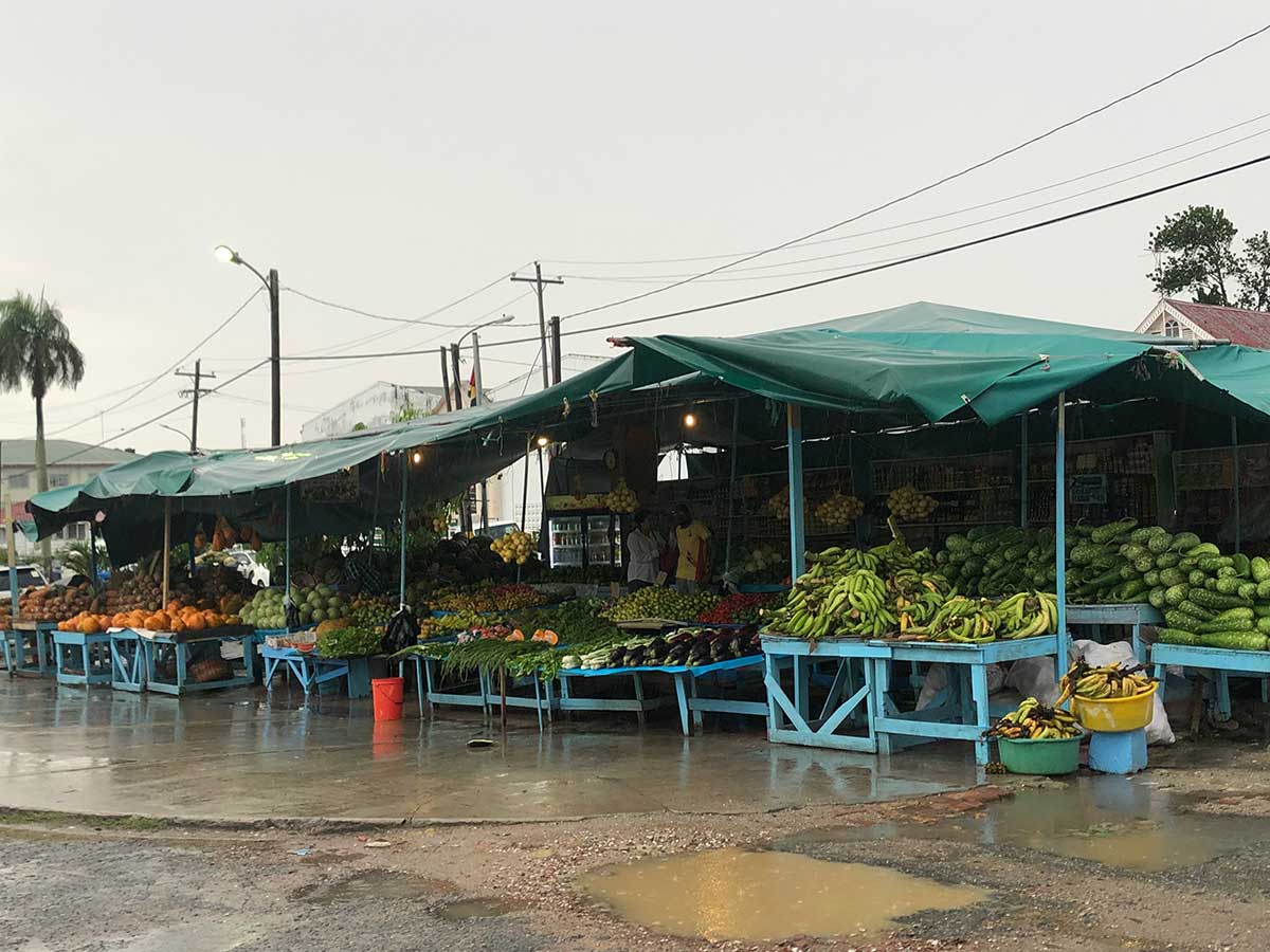 Heavy rain falls onto fruit market covered in tarps