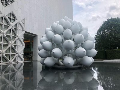 a sculpture of flower pedals sitting on water