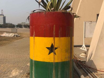 Barrel with the Ghana flag of red, yellow and greet with a black star in the center